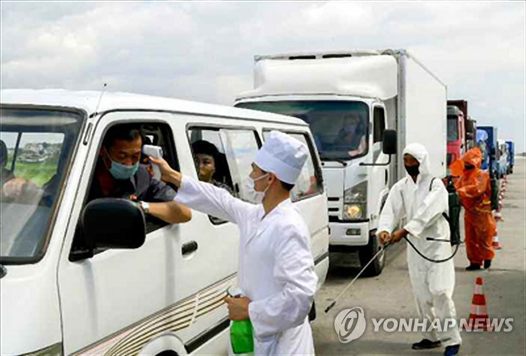 A North Korean antivirus worker takes the temperature of a car passenger by using a non-contact thermometer in this photo released by the Rodong Sinmun, the official newspaper of the North's ruling party, on July 31, 2020. (For Use Only in the Republic of Korea. No Redistribution) (Yonhap)