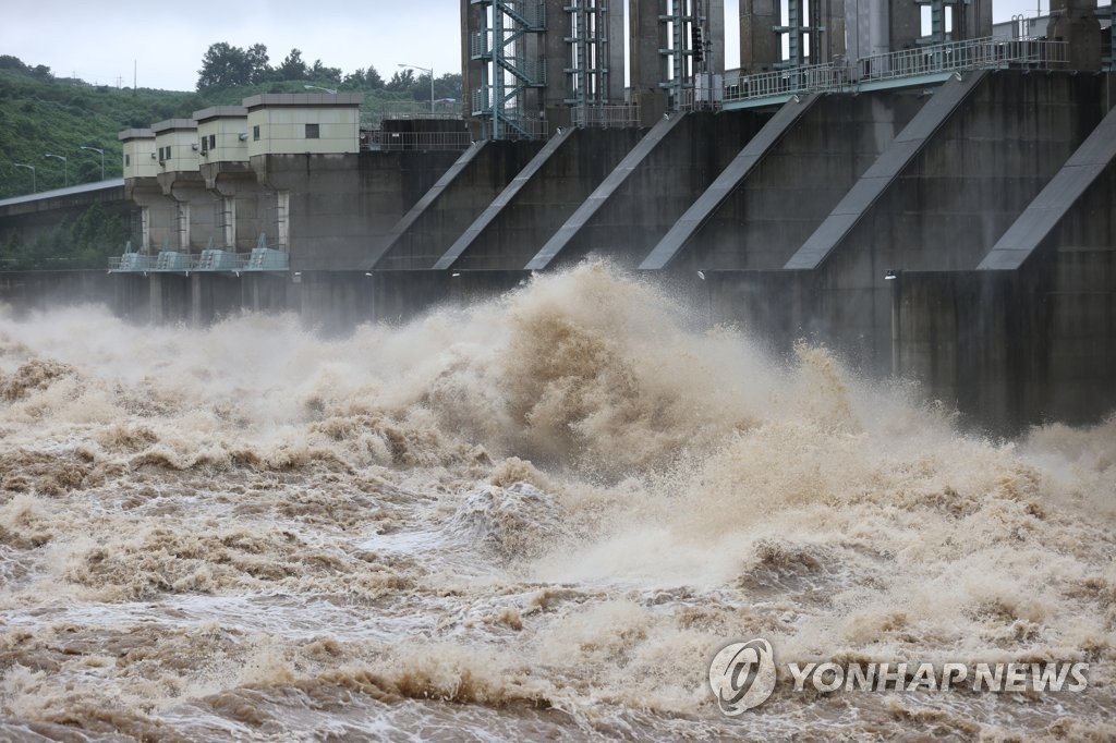 Water gushes out of the floodgates of the Gunnam Dam on the Imjin River that runs across the inter-Korean border in the South Korean border town of Yeoncheon, north of Seoul, on Aug. 6, 2020. The state-run Korea Water Resources Corp. opened all of the dam's 13 floodgates to lower the water level after the region received heavy rain. The dam, opened in 2010, was designed to deal with flash floods from North Korea. (Yonhap)