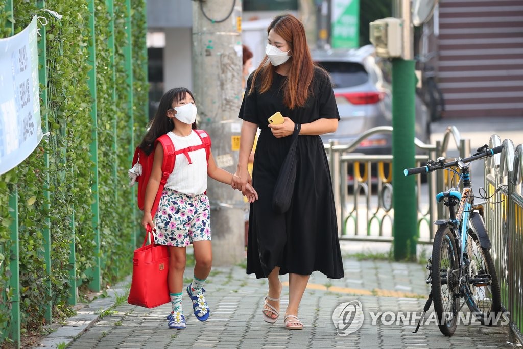 수도권 전면 원격 수업 시행 직전인 8월 25일 오전 서울 마포구의 한 초등학교 앞에서 학부모가 자녀를 등교시켜주고 있다. [연합뉴스 자료사진]