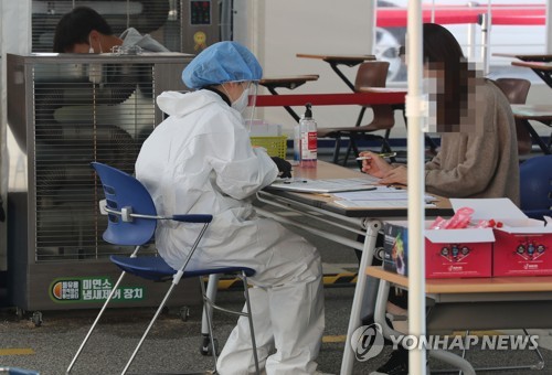A medical worker carries out new coronavirus tests at a makeshift clinic in southern Seoul on Oct. 20, 2020. (Yonhap)