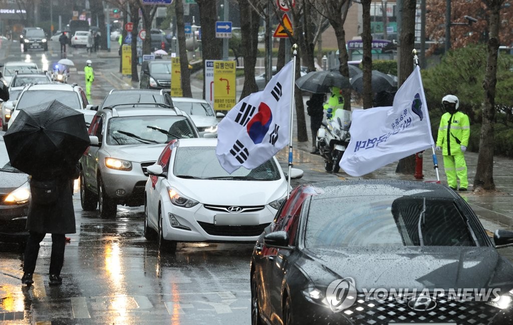 Members of a conservative group stage in-car protests against the Moon Jae-in administration in central Seoul on March 1, 2021. (Yonhap) 