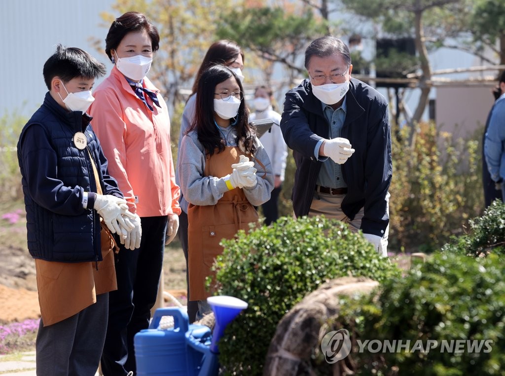 심을 나무 살펴보는 문 대통령 내외
