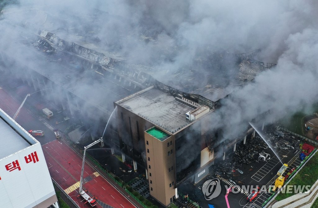Firefighters try to put out a fire at a Coupang distribution center in Icheon, some 80 kilometers south of Seoul, on June 18, 2021. (Yonhap)