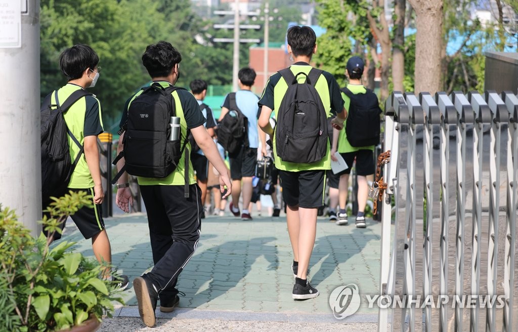 Students arrive at a middle school in Seoul on June 21, 2021, as health authorities are set to apply eased social distancing rules next month.