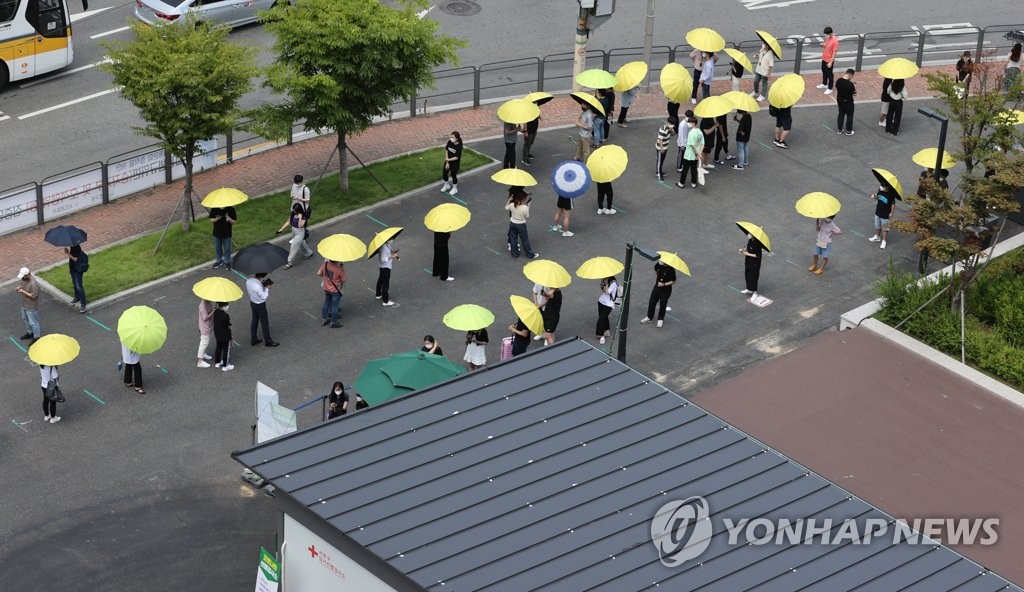 폭염 속 우산 쓰고 코로나 검사 대기하는 시민들
