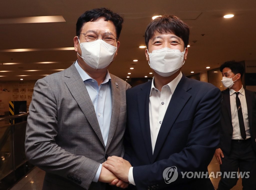 Lee Jun-seok (R), chairman of the People Power Party, and Democratic Party Chairman Rep. Song Young-gil pose for photos on July 12, 2021, following their dinner meeting at a restaurant in western Seoul. (Yonhap)