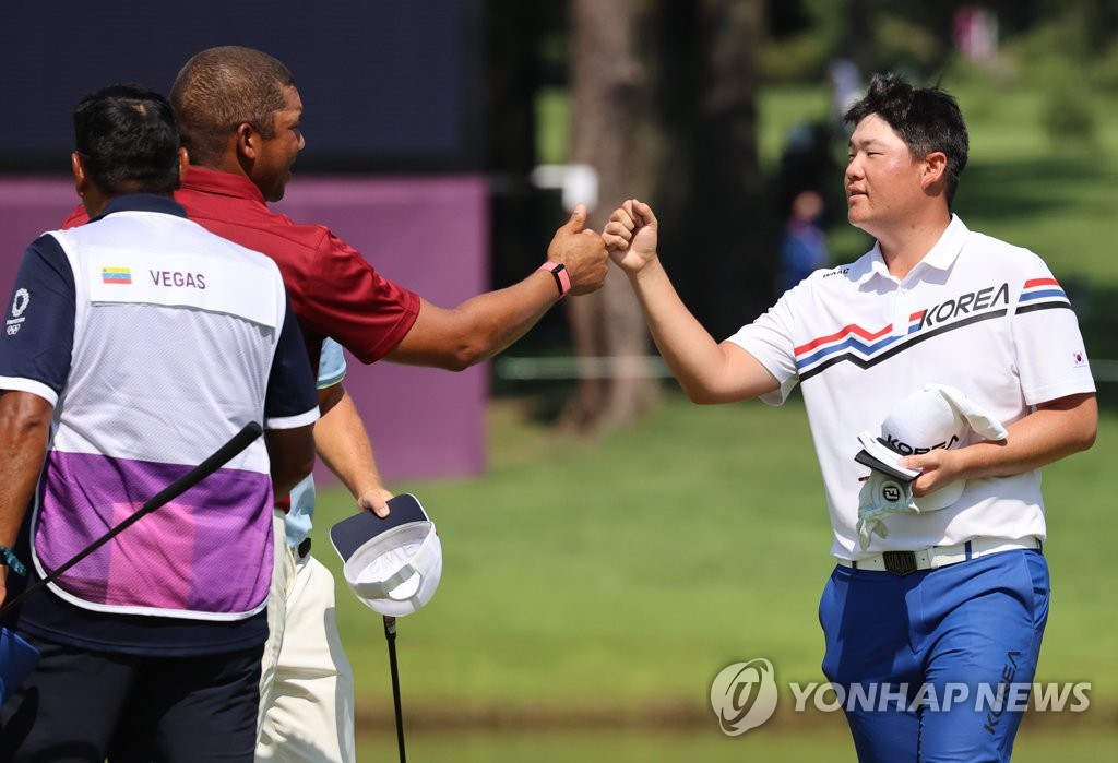 Im Sung-jae of South Korea (R) bumps fists with Jhonattan Vegas of Venezuela after completing the final round of the Tokyo Olympic men's golf tournament at Kasumigaseki Country Club in Saitama, Japan, on Aug. 1, 2021. (Yonhap)