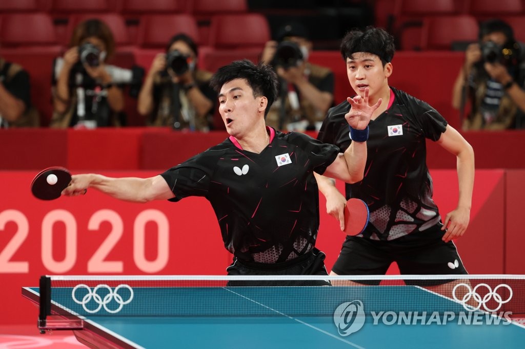 Lee Sang-su (L) and Jeoung Young-sik play Koki Niwa and Jun Mizutani of Japan during their doubles match of the bronze medal contest for the men's table tennis team event at the Tokyo Olympics at Tokyo Metropolitan Gymnasium in Tokyo on Aug. 6, 2021. (Yonhap)