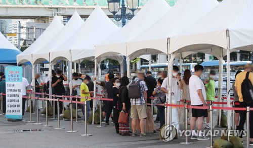 Des personnes font la queue avant de se soumettre à un test de dépistage du nouveau coronavirus (Covid-19) dans un centre provisoire installé sur la place de la gare à Séoul, le samedi 4 septembre 2021.