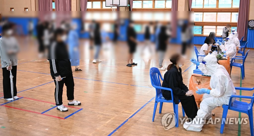 This Sept. 7, 2021, file photo shows students at a middle school in Gwangju, about 330 kilometers south of Seoul, taking a mass COVID-19 test after 13 infection cases broke out at the school. (Yonhap)