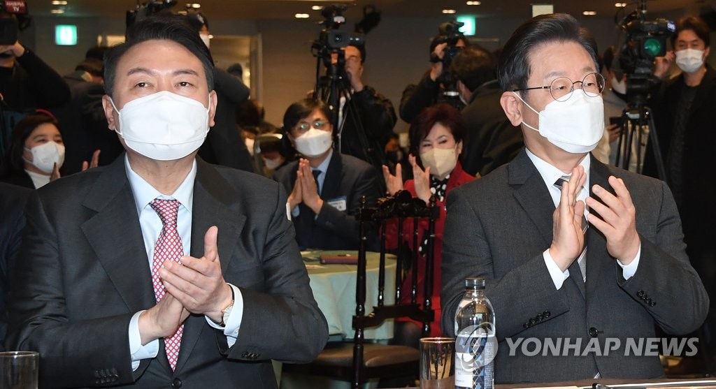 In this file photo, Yoon Suk-yeol (L), the presidential candidate of the main opposition People Power Party, and Lee Jae-myung, the candidate of the ruling Democratic Party, attend an event for small merchants in Seoul on Jan. 18, 2022. (Pool photo) (Yonhap)