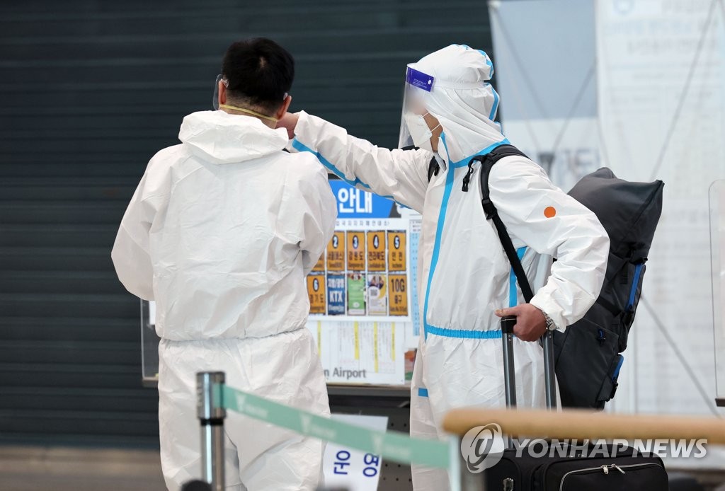방역복 착용하고 입국