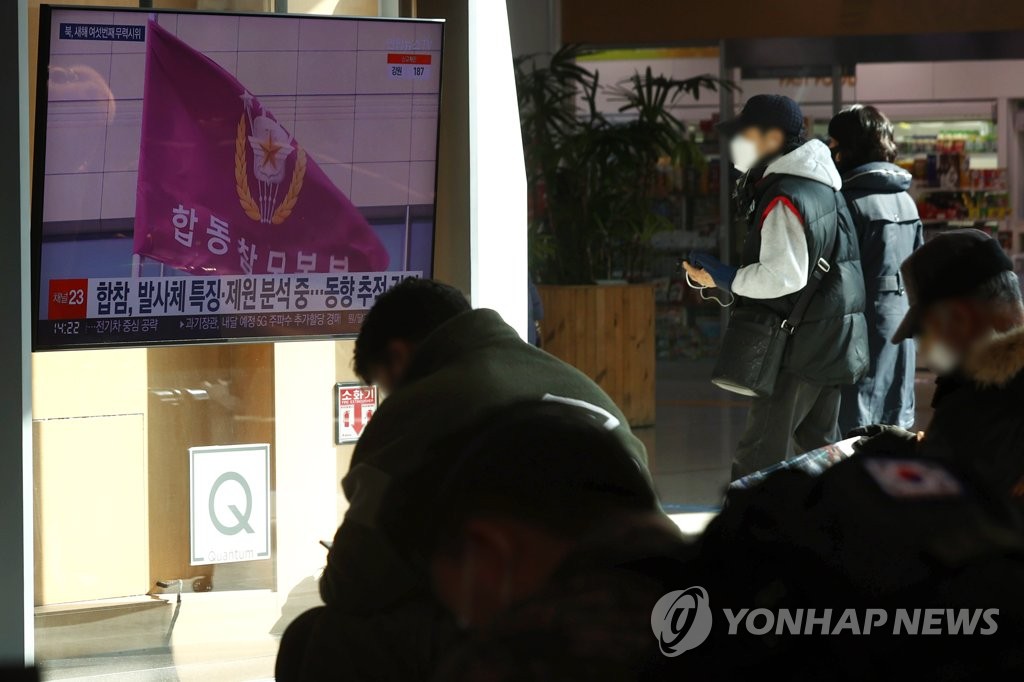 People watch news of North Korea's latest missile launch at Seoul Station on Jan. 27, 2021. (Yonhap)