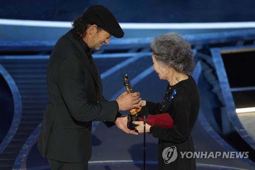 아카데미 남우조연상 트로피 건네는 윤여정