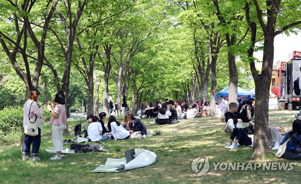 잔디밭에 앉아 축제 즐기는 학생들