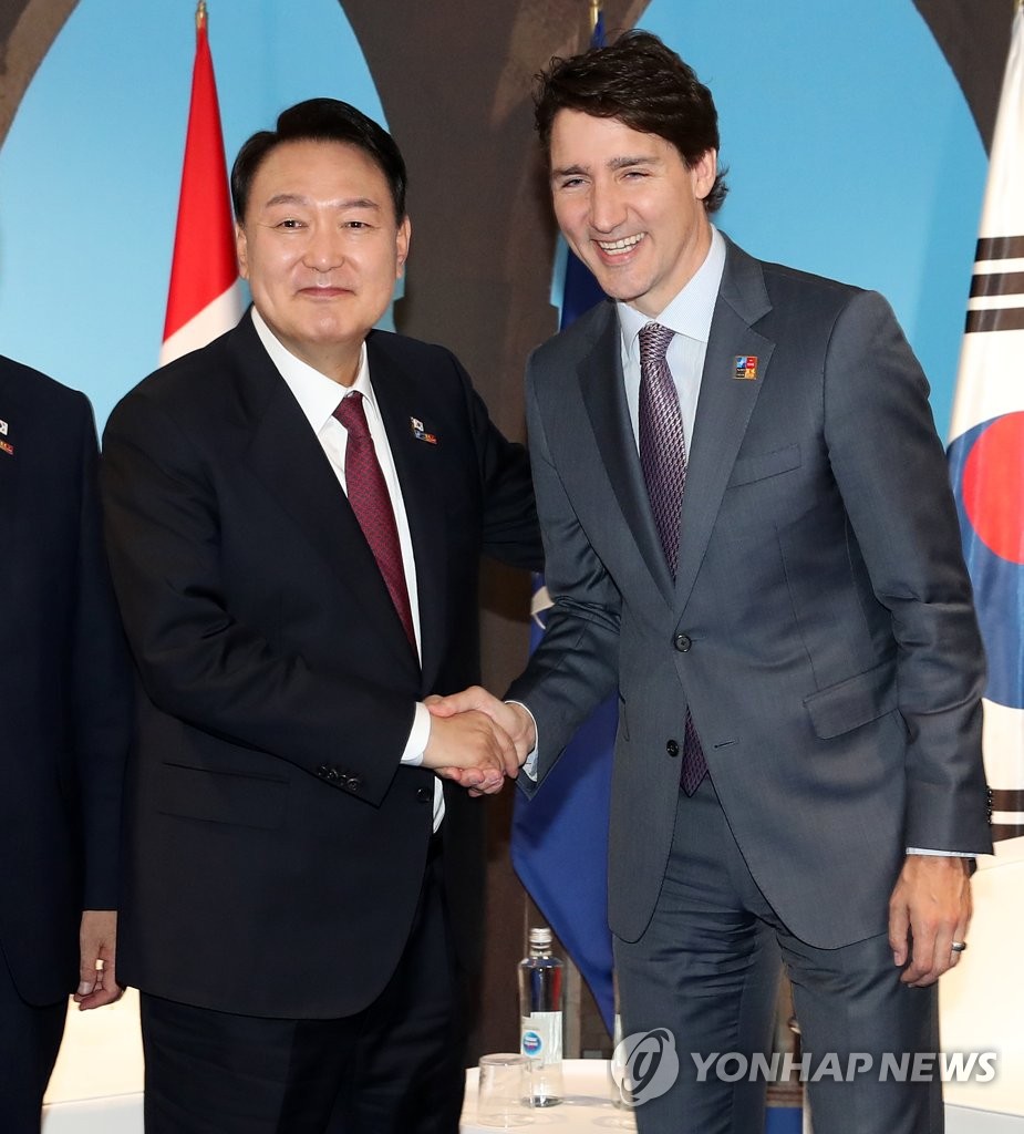 South Korean President Yoon Suk-yeol (L) shakes hands with Canadian Prime Minister Justin Trudeau prior to their talks at the IFEMA Convention Center in Madrid on June 30, 2022, on the sidelines of a summit of the North Atlantic Treaty Organization. (Yonhap)