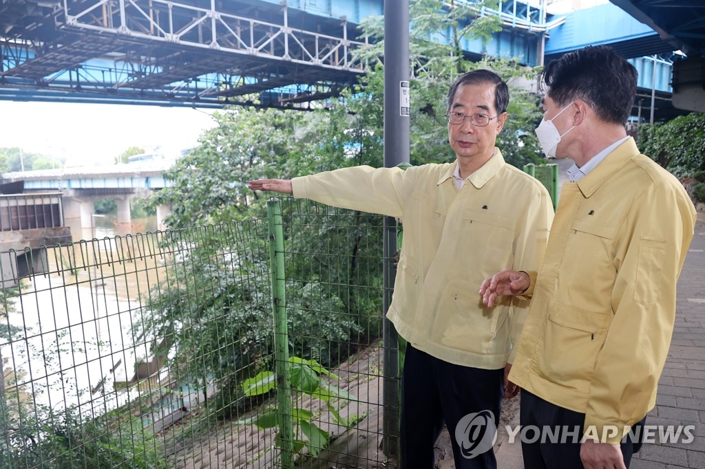 Prime Minister Han Duck-soo (L) conducts an on-site inspection of a flood control center on the Han River on Aug. 9, 2022. (Yonhap) 