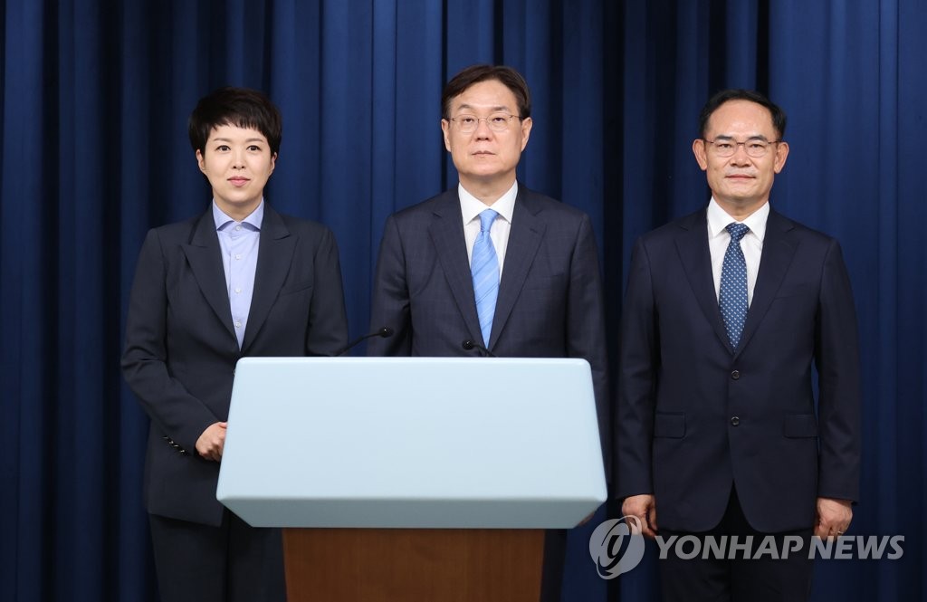 Kim Eun-hye (L), senior secretary for press affairs, Lee Kwan-sup (C), senior secretary for policy and planning and Lim Jong-deuk (R), second deputy national security adviser, pose in front of cameras at a press briefing at the presidential office in Seoul after their appointments on Aug. 21, 2022. (Yonhap)