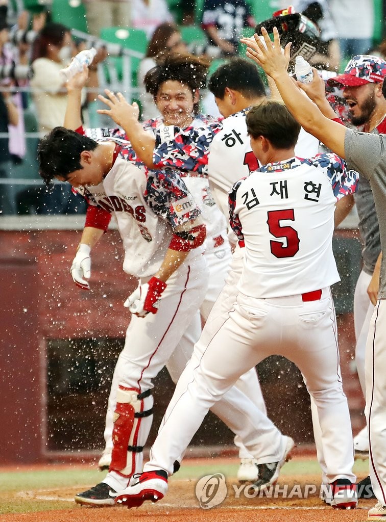 Oh Tae-gon of the SSG Landers (L) is congratulated by teammates after hitting a walkoff solo home run against the Doosan Bears in the bottom of the ninth inning of a Korea Baseball Organization regular season game at Incheon SSG Landers Field in Incheon, 30 kilometers west of Seoul, on Sept. 18, 2022. (Yonhap)