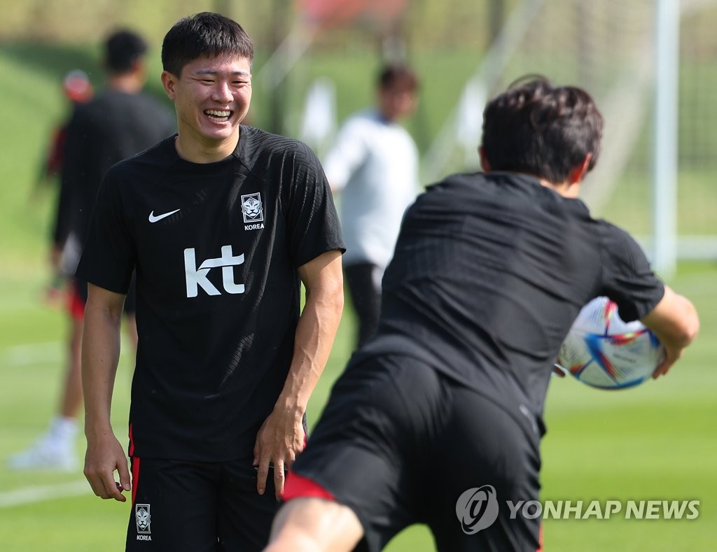 South Korean midfielder Kwon Chang-hoon (L) smiles during a training session for the FIFA World Cup at Al Egla Training Site in Doha on Nov. 19, 2022. (Yonhap)