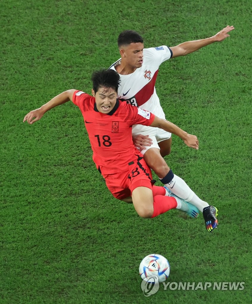 Lee Kang-in of South Korea (L) and Matheus Nunes of Portugal battle for the ball during the countries' Group H match at the FIFA World Cup at Education City Stadium in Al Rayyan, west of Doha, on Dec. 2, 2022. (Yonhap)