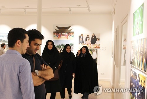 Visitors look at a photo exhibition co-hosted by Yonhap News Agency and IRNA at the Artists House in Tehran on Sept. 27, 2016. (Yonhap)