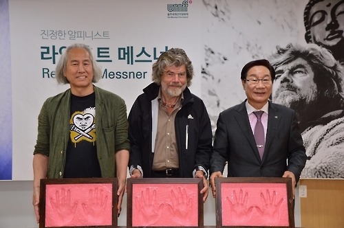 Reinhold Messner (C), a legendary German alpinist who has conquered all 14 peaks of the Himalayas without supplemental oxygen, poses with Ulju County chief Shin Jang-yeol (R) and animation professor Park Jae-dong during a handprint event in the Ulju Mountain Film Festival in the southeastern county of Ulju on Oct. 1, 2016. (Yonhap) 