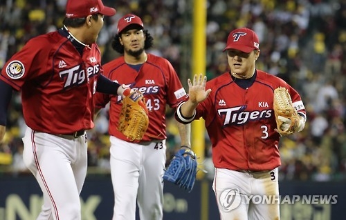 Kia Tigers' shortstop Kim Sun-bin (R) high-fives second baseman An Chi-hong after the two turned a double play against the LG Twins during the Korea Baseball Organization's wild card game in Seoul on Oct. 10, 2016. (Yonhap)