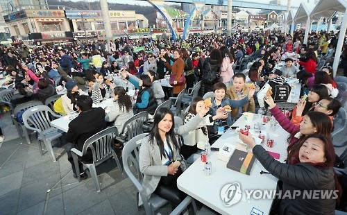 This file photo dated on March 28, 2016, shows some 4,500 employees of Chinese cosmetics and health supplement maker Aolan International Beauty Group, who are on a group tour to South Korea, enjoying fried chicken and beer, locally called "chimaek", at a massive outdoor party in the western port city of Incheon. (Yonhap)
