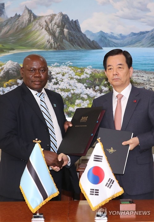 Defense Minister Han Min-koo (R) shakes hands with his Botswana counterpart Shaw Kgathi after signing an agreement for military cooperation in Seoul on Jan. 18, 2017. (Yonhap) 