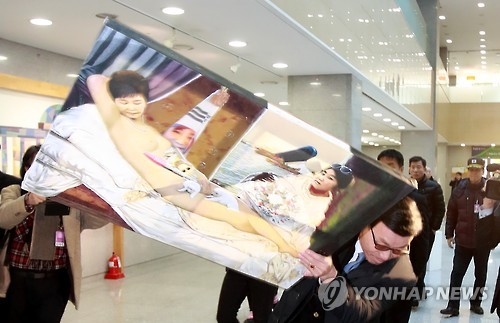 Members of a conservative civic group take away a painting titled "Dirty Sleep," which portrays President Park Geun-hye in the nude, from an exhibition at the National Assembly building in Seoul on Jan. 24, 2017. The exhibition was hosted by Pyo Chang-won, a lawmaker of the main opposition Democratic Party. (Yonhap) 