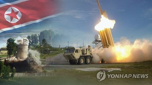 In this undated captured image from Yonhap News TV, a THAAD system (R) is shown firing an interceptor and a nuclear facility in North Korea against its national flag. (Yonhap)