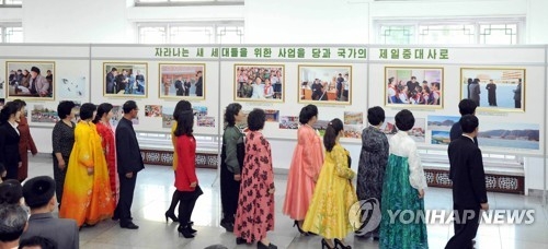 This photo unveiled by North Korea's Central News Agency on April 4, 2017, shows North Koreans seeing photos of leader Kim Jong-un's feats at an exhibition held in Pyongyang to mark the fifth anniversary of him being elected to the top posts of the country. (For Use Only in the Republic of Korea. No Redistribution) (Yonhap)