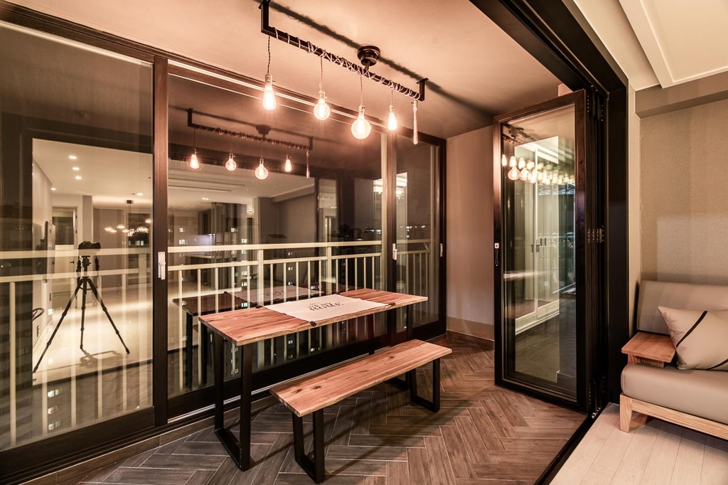 This file photo, provided by Zipdeco, captures a renovated cafe-like balcony of an apartment in Ilsan, north of Seoul, on April 7, 2017. The windows and sliding doors have been redecorated with black frames to match the dark Herringbone wood floor. (Yonhap) 