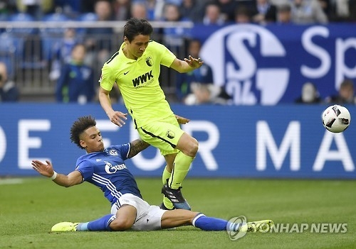 In this Associated Press photo taken on March 12, 2017, Koo Ja-cheol of FC Augsburg (R) is tackled by Thilo Kehrer of FC Schalke 04 during their Bundesliga football match in Gelsenkirchen, Germany. (Yonhap)