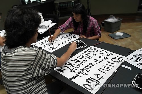 This file photo, dated Oct. 8, 2012, shows students engaging in a contest writing the Korean alphabet, or "hangeul," ahead of an opening ceremony at the Autonomous University of Nayarit in Tepic, the capital of Mexico's Nayarit State, for a King Sejong Institute Korean-language learning facility. (Yonhap)