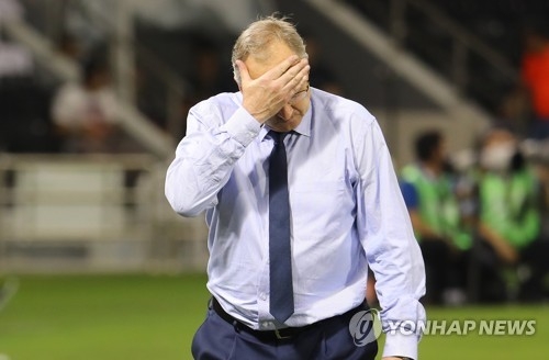 South Korea men's football head coach Uli Stielike wipes off sweat during the team's 3-2 loss to Qatar in their World Cup qualifying match at Jassim Bin Hamad Stadium in Doha on June 13, 2017. (Yonhap)