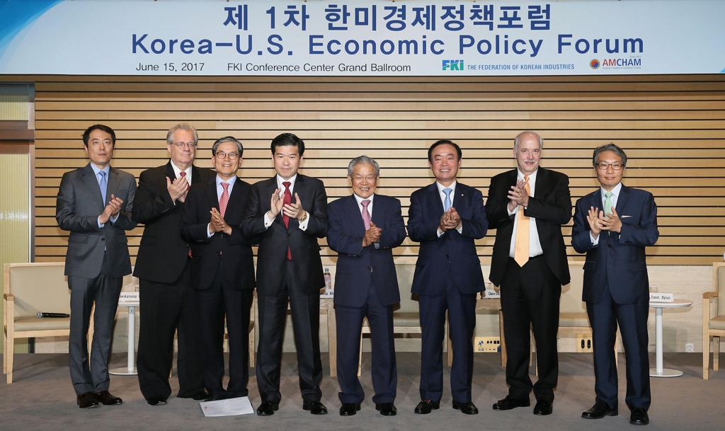 In this photo taken on June 15, 2017, AMCHAM Chairman James Kim (4th from left), FKI Vice Chairman Kwon Tae-shin (5th from left) and other participants clap their hands in the first Korea-U.S. Economic Policy Forum held in Seoul. (Yonhap)