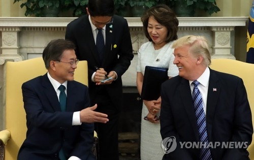 South Korean President Moon Jae-in (L) and U.S. President Donald Trump both laugh at remarks from the South Korean leader in their one-on-one meeting at the White House on June 30, 2017. The bilateral summit was quickly followed by an expanded summit, involving other top government officials from both sides. (Yonhap)