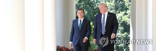 South Korean President Moon Jae-in (L) and U.S. President Donald Trump walk toward the White House Rose Garden, where they held a joint press conference following their bilateral summit on June 30, 2017. (Yonhap)