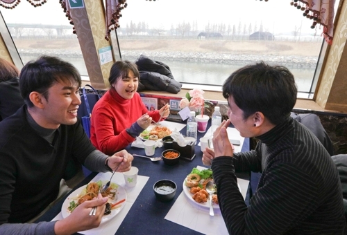 Tourists enjoy a meal on a cruise ship. (Yonhap) 