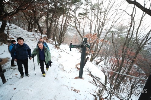 President Moon Jae-in (R) climbs Mount Bukhan on New Year's Day on Jan. 1, 2018. (Yonhap) 