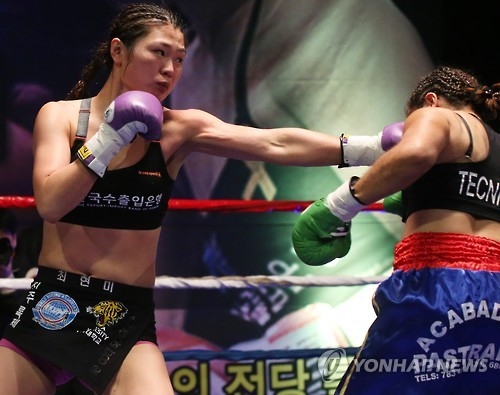 In this file photo taken March 27, 2016, South Korean boxer Choi Hyun-mi (L) delivers a blow to Colombia's Diana Ayala in their World Boxing Association (WBA) women's super featherweight title bout in Gwangmyeong, Gyeonggi Province. (Yonhap)