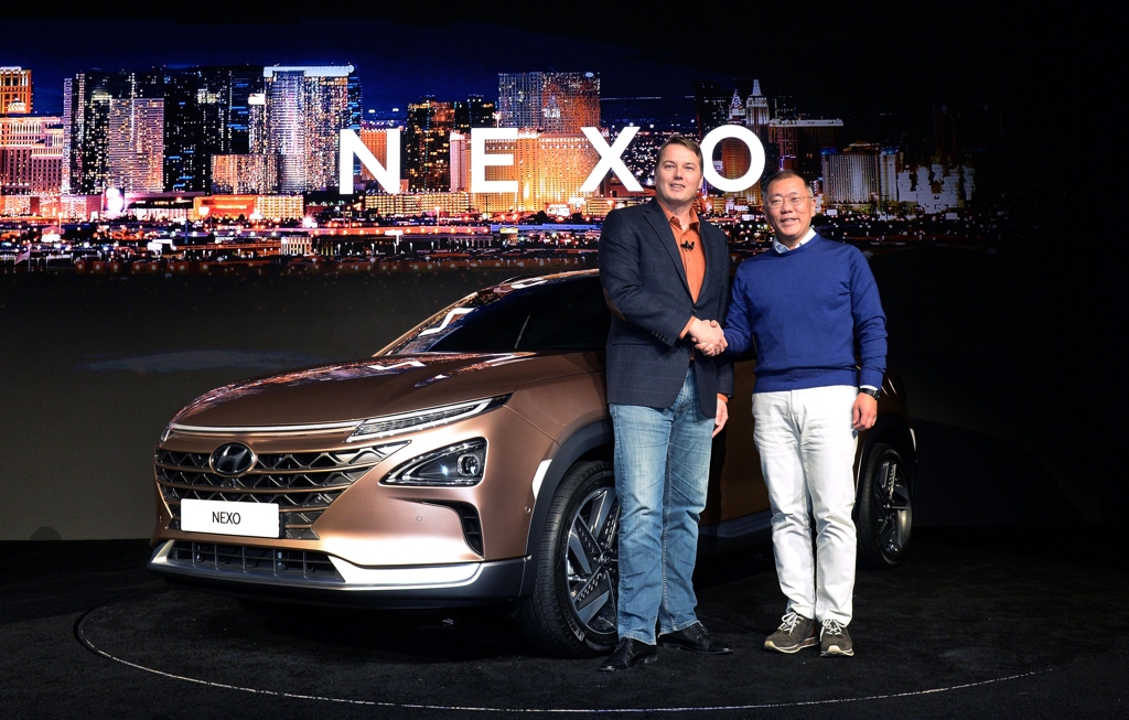 In this photo taken Jan. 8, 2017, and provided by Hyundai Motor, Hyundai Motor Vice Chairman Chung Eui-sun (R) and Aurora Innovation's CEO Chris Urmson shake hands beside the NEXO at CES 2018. (Yonhap)