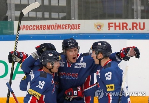 In this Reuters file photo taken Dec. 16, 2017, South Korean forward Mike Testwuide (C) celebrates his goal against Sweden with teammates Kim Sang-wook (L) and Eric Regan during the Channel One Cup hockey game at VTB Ice Palace in Moscow. (Yonhap)