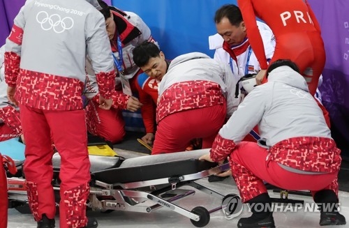 North Korean short track speed skater Choe Un-song (C) writhes in pain after crashing into safety padding during training at Gangneung Ice Arena in Gangneung, Gangwon Province, on Feb. 2, 2018. (Yonhap)
