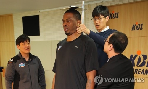 In this file photo taken April 6, 2018, Korean Basketball League (KBL) officials measure the height of Jeonju KCC Egis player Charles Rhodes (C) at the KBL Center in Seoul. (Yonhap)