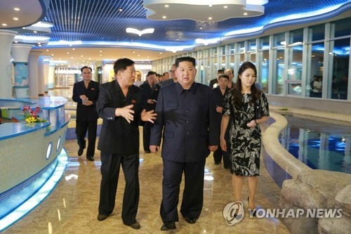 A June 9, 2018, photo from the Rodong Sinmun shows North Korean leader Kim Jong-un (C) and his wife Ri Sol-ju visiting a new seafood restaurant in Pyongyang. (For Use Only in the Republic of Korea. No Redistribution) (Yonhap)