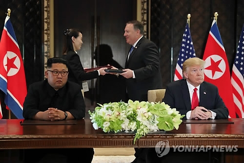 This photo shows U.S. President Donald Trump (R) and North Korean leader Kim Jong-un (L) at the Capella Hotel in Singapore after signing a landmark agreement aimed at denuclearization of the Korean Peninsula on June 12, 2018. (Yonhap)
