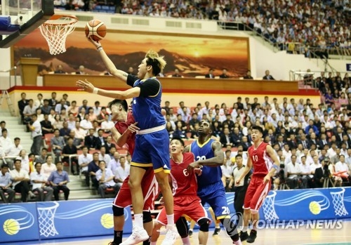 In this Joint Press Corps photo, Choi Jun-yong of South Korea (with ball, in blue) attempts a layup against North Korea during their friendly basketball game at Ryugyong Chung Ju-yung Gymnasium in Pyongyang on July 5, 2018. (Yonhap)
